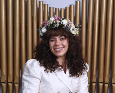 Rebekah Okpoti sits in front of an organ.